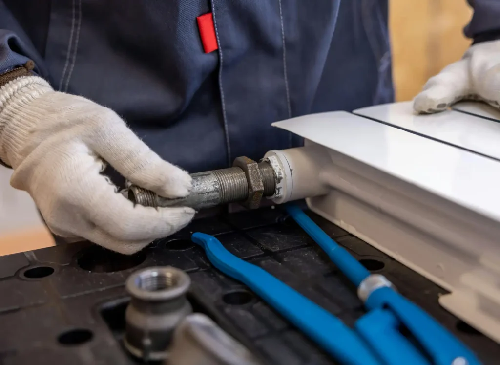 Emergency plumber repairing a radiator pipe connection in a Slough home